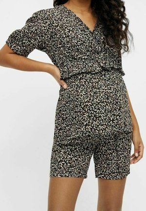 Zwarte playsuit met bloemenprint, korte mouwen, V-hals en elastische tailleband. Heeft lichtgekleurde bladpatronen op een donkere achtergrond.