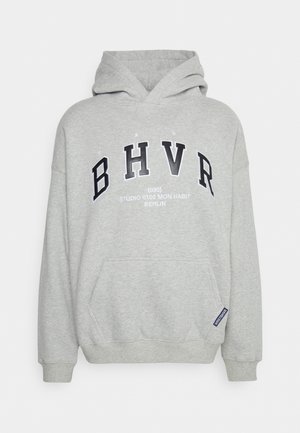Sweat à capuche gris clair avec des lettres BHVR en noir et blanc et un petit texte indiquant "STUDIO 0102 MON HABIT BERLIN" à l'avant.