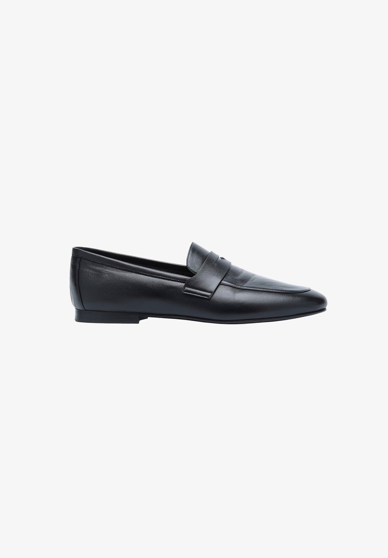 Mocassin en cuir noir avec un petit talon et une bride décorative sur le dessus, vu de côté sur fond blanc.