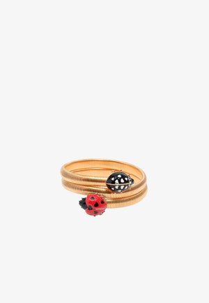 Bracciale a spirale color oro con charms a forma di coccinella rossa e nera, dettagli a forma di cuore, texture liscia e finitura levigata.