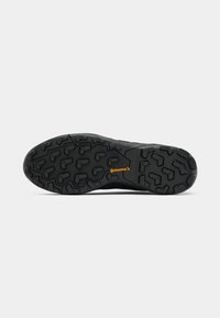 Schwarze Gummisohle mit robustem Profil und orangefarbenem "Continental"-Logo, zentriert auf weißem Hintergrund.