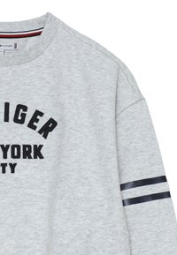 Felpa grigia con scollo rotondo e testo ricamato nero "TOMMY HILFIGER NEW YORK CITY." Presenta strisce blu sulla maniche.