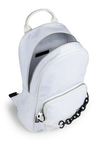 Mochila blanca de nylon con forma redondeada, doble cremallera, bolsillo frontal con acento de cadena negra y un asa en la parte superior para llevarla.