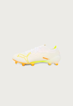 Hvide og neon gule Puma fodboldstøvler med orange knopper og logo, designet til spil på fast underlag.