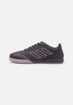 Zapatillas deportivas negras con parte superior texturizada, que presentan tres rayas blancas en el costado y una suela de goma con un acento púrpura claro.