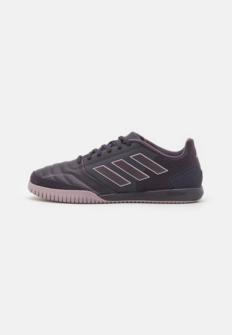 Zapatillas deportivas negras con parte superior texturizada, que presentan tres rayas blancas en el costado y una suela de goma con un acento púrpura claro.