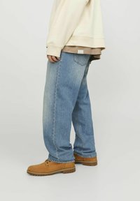 Light blue jeans with a straight-cut design, featuring a classic five-pocket layout and contrasting stitching. Durable fabric and relaxed fit.