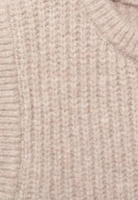 Ljusbeige stickad tröjtyg med ribbtextur, som har vertikala linjer och ett mjukt, lurvigt utseende.