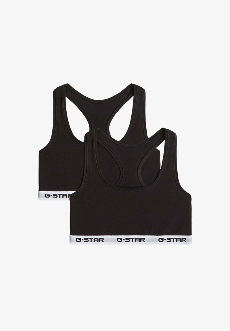 Deux brassières de sport noires avec dos nageur, bandes élastiques blanches à l’ourlet, chaque bande présentant le texte noir « G-STAR » répété.