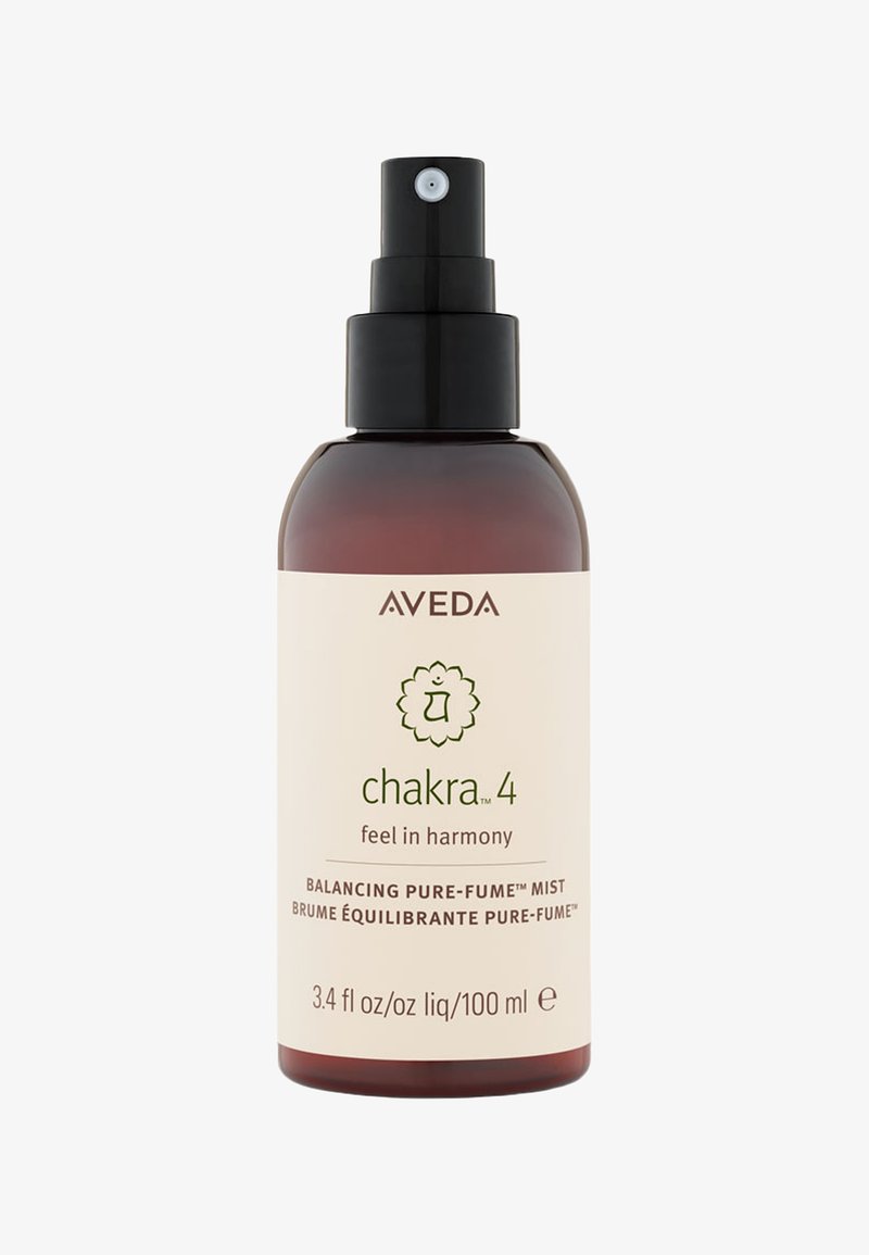 Bruine glazen fles met een zwarte spuitmond, met een crèmekleurig etiket met groene tekst en een chakra-symbool. Inhoud: 3,4 fl oz (100 ml).