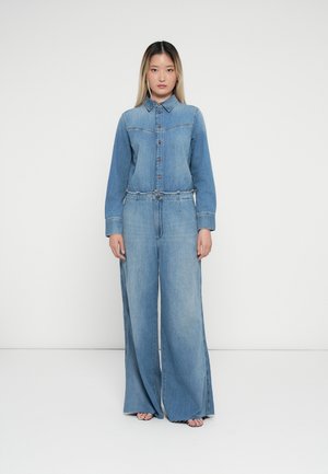 Jumpsuit in denim con chiusura a bottoni, maniche lunghe e gambe larghe. Lavaggio azzurro chiaro con dettagli di cucitura e vita elastica.