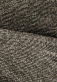 Kudottu kangas tumman harmaana, jossa on hienovarainen ruutukuvio. Pehmeä rakenne ja hieman kohollaan oleva pinta, sopii verhoiluun tai muotiin.