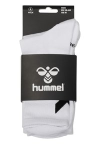 Calcetines blancos en un paquete de seis, hechos de una mezcla de algodón, con un logotipo y acentos negros. Empaquetados en una tarjeta negra con un gancho para colgar.