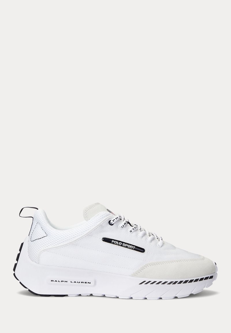 Vita idrottssko med mesh- och mockamaterial, en texturerad sula och svarta accenter, med "POLO SPORT"-logotyp på sidan.