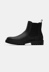 Melnas ādas Čelsi zābaki ar elastīgām sānu paneļiem, vilkšanas cilpu un izturīgu zoli ar dziļām protektora rievām, kas nodrošina labu saķeri.