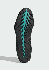 Black sports shoe sole with a textured surface, featuring a turquoise accent in a leaf pattern and pronounced tread for grip.