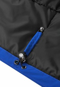 Schwarzer isolierter Stoff mit blauem Rand, ausgestattet mit einem Knebelverschluss, Kordelstopper und sichtbaren Nähten. Glatte Textur mit praktischen Designelementen.