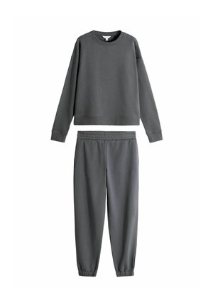 Sweat shirt gris et joggeurs assortis en tissu doux. Le sweat shirt a un col rond et des manches longues, tandis que le pantalon est doté d'une taille élastique.