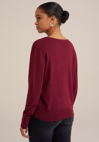 Maglione a maglia bordeaux con maniche lunghe e vestibilità comoda, caratterizzato da un ampio scollo e finiture a costine all'orlo e ai polsini.