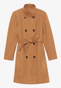 Kamelinvärinen villakangastakki, jossa korkea kaulus, kaksirivinen malli, mustat napit, vyötärölle sidottava vyö ja sivutaskut.