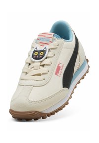 Baskets en toile crème avec des accents en daim noir, doublure intérieure bleue et un verrou de lacet en forme de chat. Présente une semelle en caoutchouc marron et le logo Puma.