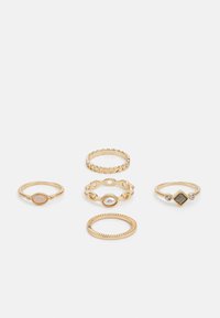 Set aus fünf goldenen Ringen mit unterschiedlichen Designs: einer mit einem ovalen Stein, einer mit einem strukturierten Band und mehrere mit dekorativen Akzenten.