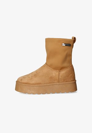 Stivali alla caviglia color cammello con una parte inferiore in morbido suede e una parte superiore in finta pelle liscia. Suola con plateau spesso e dettagli di presa testurizzati.