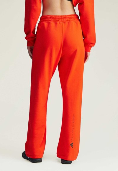 Pantaloni della tuta rosso brillante con una vestibilità rilassata, vita elastica e il marchio "Stella McCartney" stampato in nero sulla gamba sinistra.