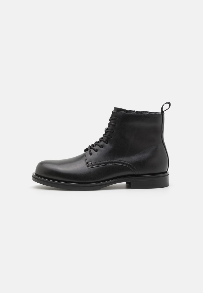 Black leather ankle boots with a rounded toe, lace-up front, and a small pull tab at the heel. Flat sole and smooth texture.