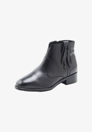 Schwarze Leder-Stiefelette mit niedrigem Absatz, spitzer Zehenpartie, seitlichem Reißverschluss und dekorativen Quasten an der Außenseite.