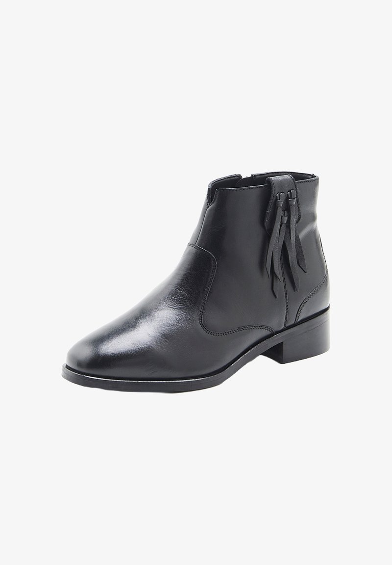 Botín de cuero negro hasta el tobillo con tacón bajo, punta afilada, cremallera lateral y borlas decorativas en el lado exterior.
