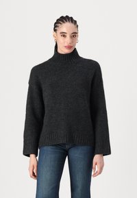Pulover supradimensionat, de culoare gri închis, cu guler înalt, realizat dintr-un tricot moale și texturat. Are mâneci largi și un tiv cusut în relief pentru un detaliu suplimentar.
