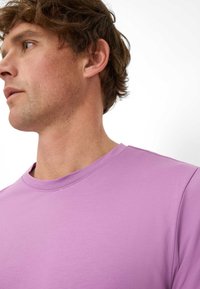 T-shirt viola chiaro a maniche corte con scollo rotondo e tessuto liscio. Presenta dettagli di cucitura minimi e una vestibilità rilassata.