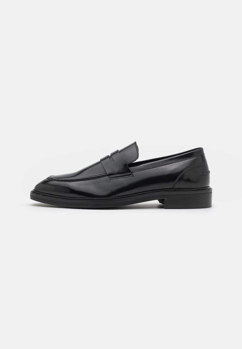 Mocassin penny en cuir noir avec bout rond, talon bas et finition polie élégante, présenté de profil sur fond blanc.