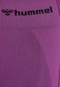 Paarse sportkleding met een geribbeld textuur, met een zwart "hummel" logo. Accentueert met effen en gemusterde stof.