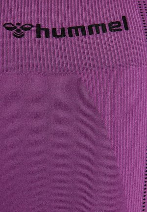 Close-up van paars gestructureerde stof met zwart "hummel" logo en bijenembleem gebreid vlakbij de bovenkant.