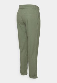 Olivgrönbyxor med avslappnad passform, elastisk midja och två bakfickor. Uppvikta fållar och texturerad tygdetalj bak.
