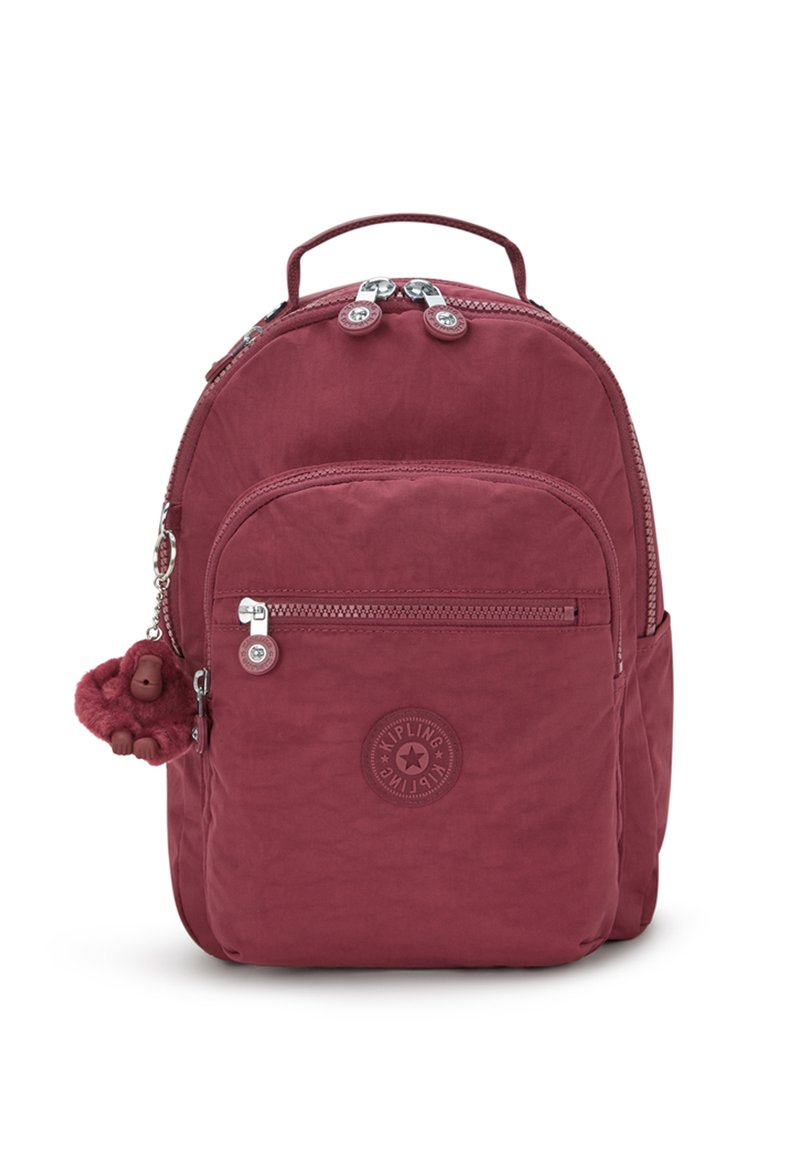 Bordeaux nylon rugzak met ritscompartimenten, logo patch en een fluffy aap sleutelhanger bevestigd aan de rits.
