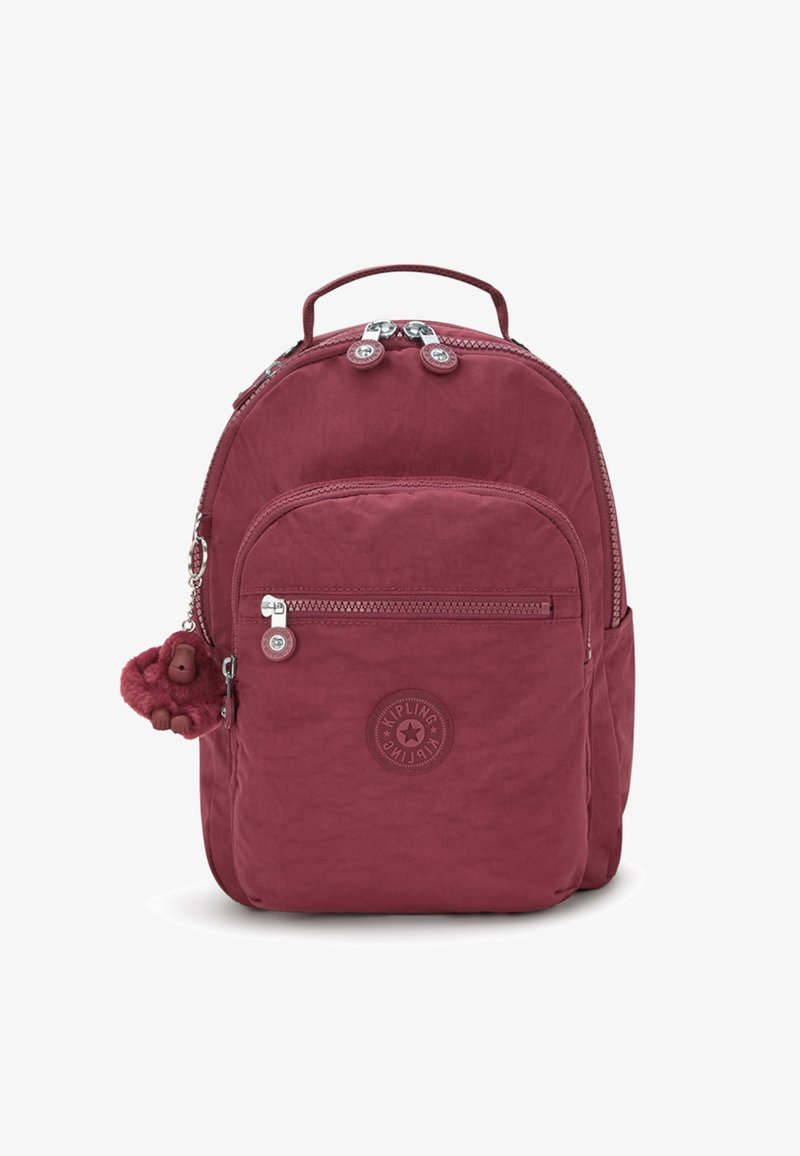 Bordeaux nylon rugzak met ritscompartimenten, logo patch en een fluffy aap sleutelhanger bevestigd aan de rits.