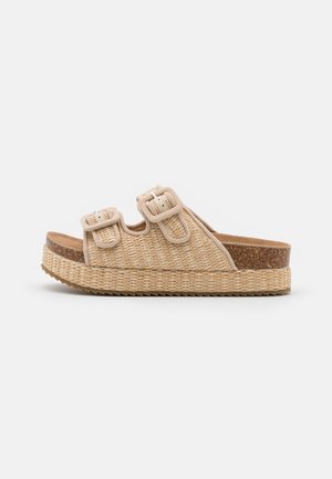 Beige woven platform sandal with two adjustable buckled straps and cork footbed on a ridged sole, shown in side profile.