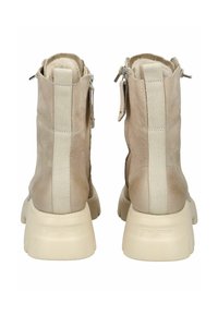Stivaletti alla caviglia in pelle beige con pannelli laterali in elastico, superficie testurizzata e suole spesse color crema. Presentano cerniere e dettagli con il marchio.