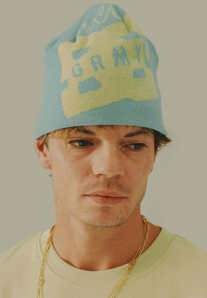 Gorro de punto en azul con diseño gráfico amarillo. Textura suave, forma ajustada, con letras en negrita y patrones divertidos en la parte superior.