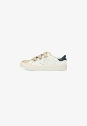 Witte sneaker met een glanzende gouden neuskap, beige klittenbanden, groene leren hakaccenten en een geperforeerd ontwerp aan de zijkant. Platte rubberen zool.