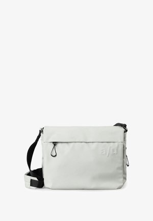 Borsa a tracolla grigia chiara realizzata in tessuto con una superficie liscia. Presenta una patta pieghevole, una tracolla regolabile e una marcatura minimale.