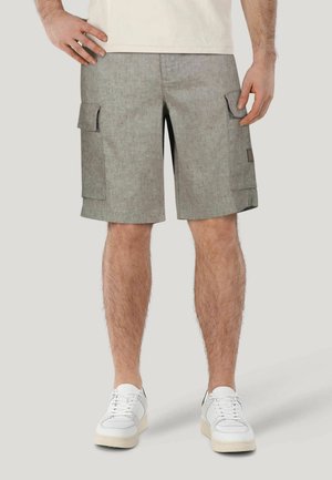 Cargo-Shorts aus hellgrauem Stoff mit strukturiertem Finish. Verfügt über Seitentaschen und einen lockeren Schnitt, kombiniert mit weißen Turnschuhen.