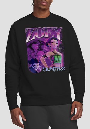 Man wearing black sweatshirt with purple graphic of animated character Zoey in three poses and text "ZOEY" and "HUNTR/X."