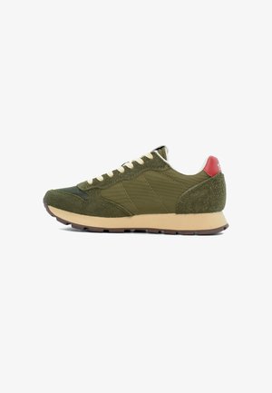 Grüne Sneakers mit Obermaterial aus Wildleder und Nylon, beigem Zwischensohlenteil und rotem Akzent an der Ferse. Ausgestattet mit runden Schnürsenkeln und einer strukturierten Außensohle für besseren Grip.