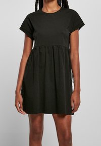 Černé šaty s krátkým rukávem vyrobené z bavlny, kulatý výstřih a nařasený pas. Jednoduchý design se přímým střihem a měkkou texturou.