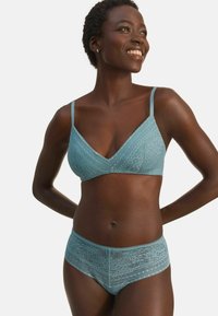 Helles blaues Spitzen-Bralette mit dreieckiger Form und verstellbaren Trägern, kombiniert mit passenden Spitzen-Hipster-Shorts, die mit Blumenmustern versehen sind.