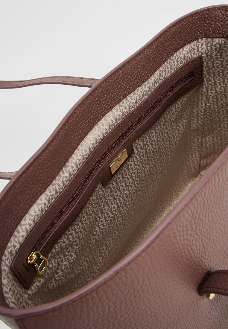 Braune, strukturierte Leder-Tote-Tasche mit einem Reißverschluss-Innentäschchen. Das Futter zeigt ein dezentes Muster in Beigetönen.